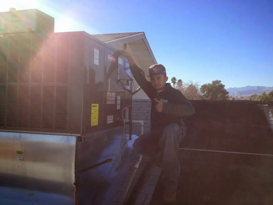 HVAC technician performing AC Tune-Up on a rooftop unit in Ephraim