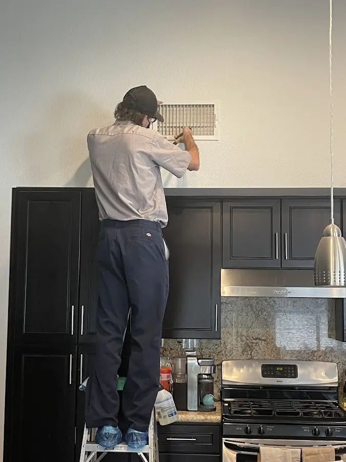 Technician inspecting an air vent during HVAC service in Ephraim